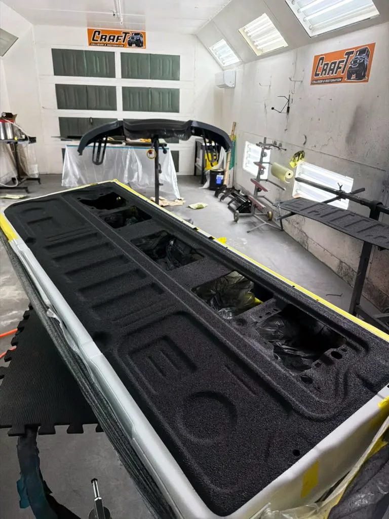 Pickup truck bed with a fresh black spray-in bedliner applied at Craft Collision in Lake Worth Beach